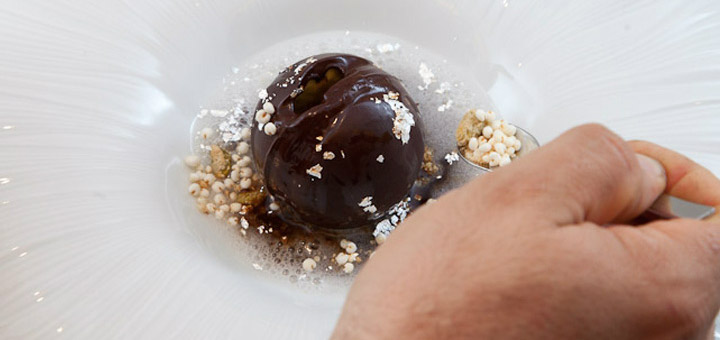 Chocolate sphere, hazelnut parfait, white rum foam, coffee, fruit, nut sand